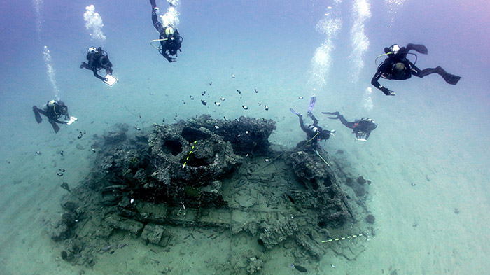 divers examing wreak of WWII amphibious assault vehicle sites near Maui