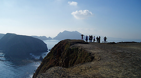 people looking to the sea from an island overlook